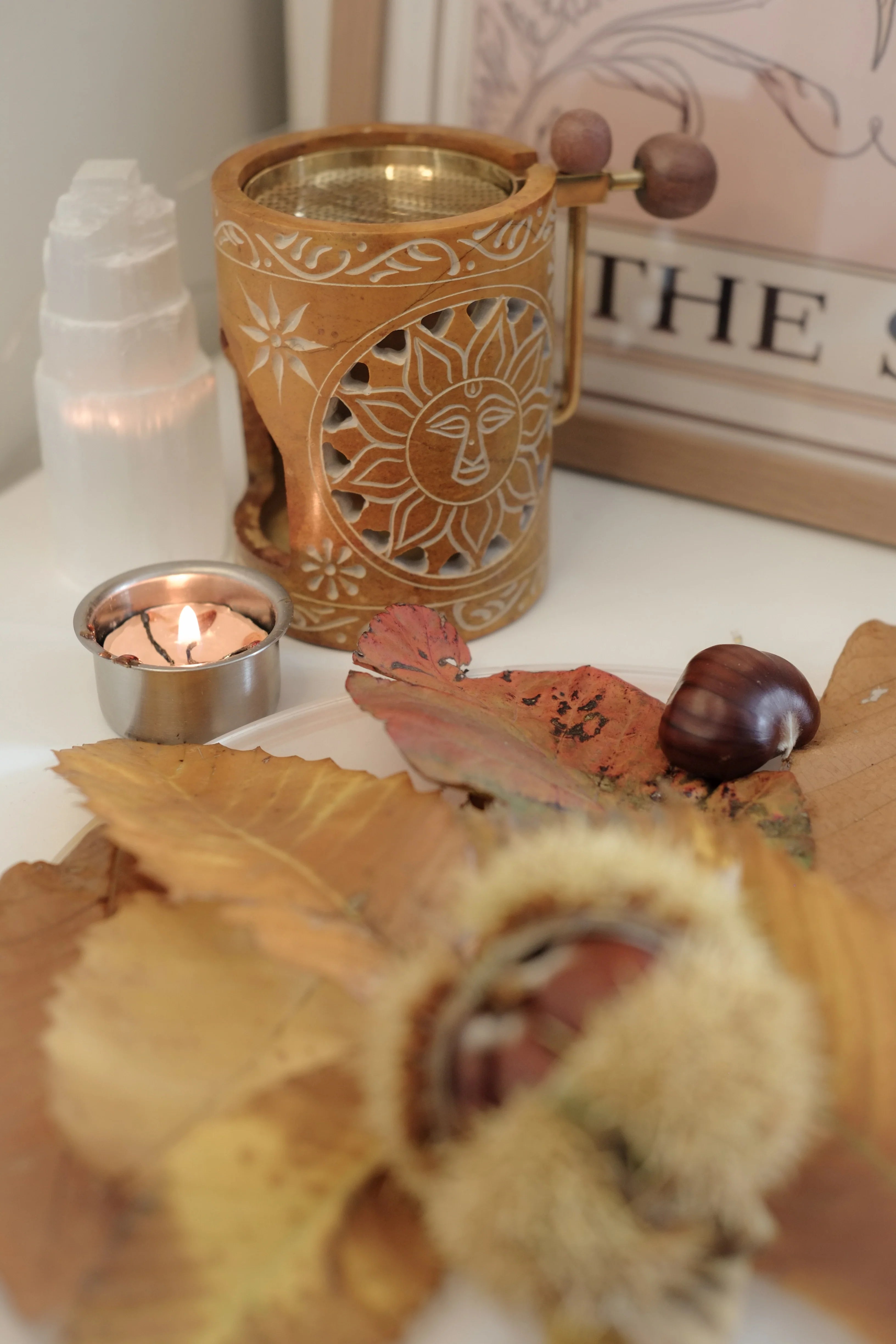 Décor automnal avec les lettres de Scrabble qui épellent "Hello Autumn", des feuilles mortes, des citrouilles, des pommes de pin et des bâtons de cannelle sur un fond noir style ardoise.