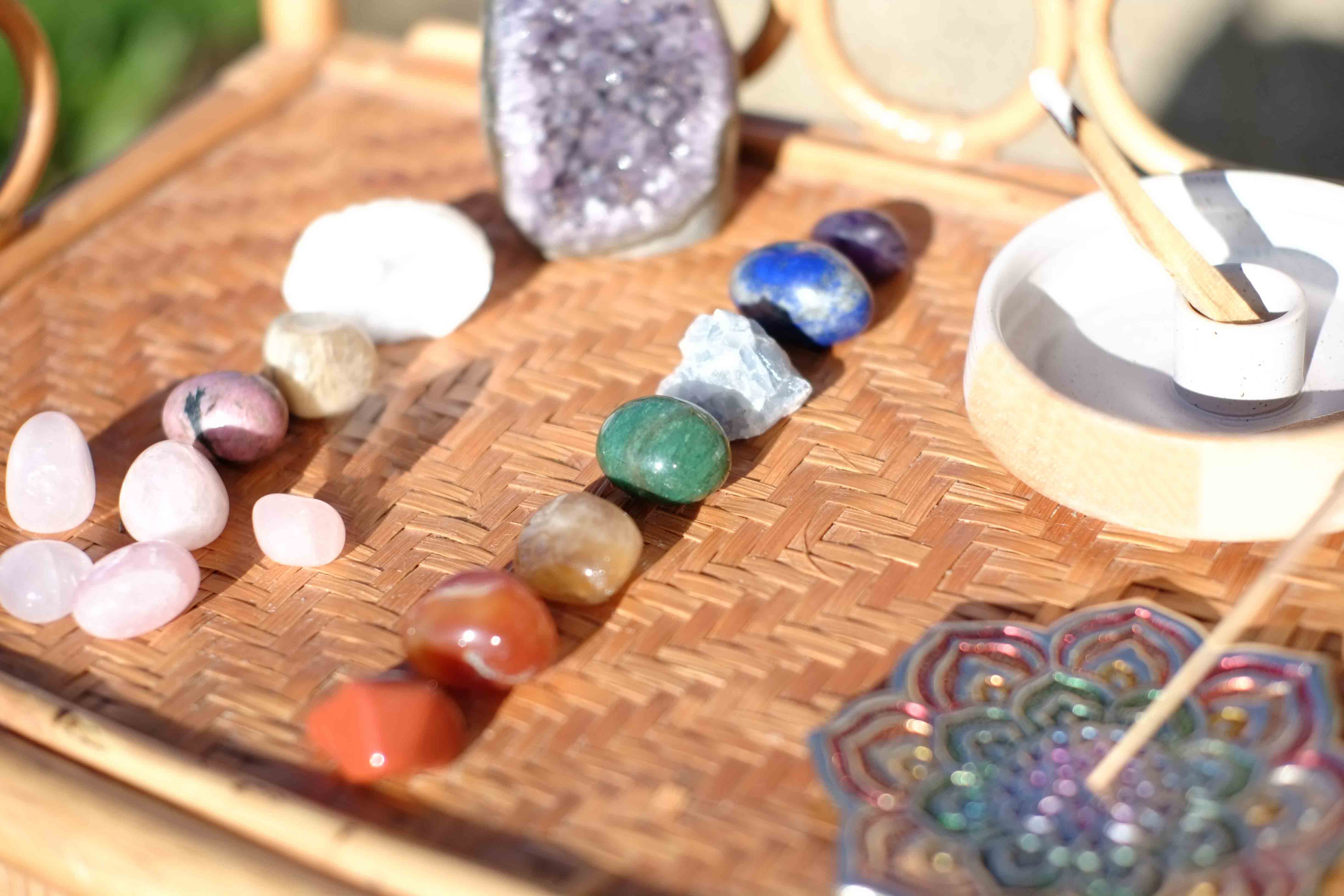 Photo ensoleillée des pierres des 7 chakras avec une géode d'améthyste et des portes encens