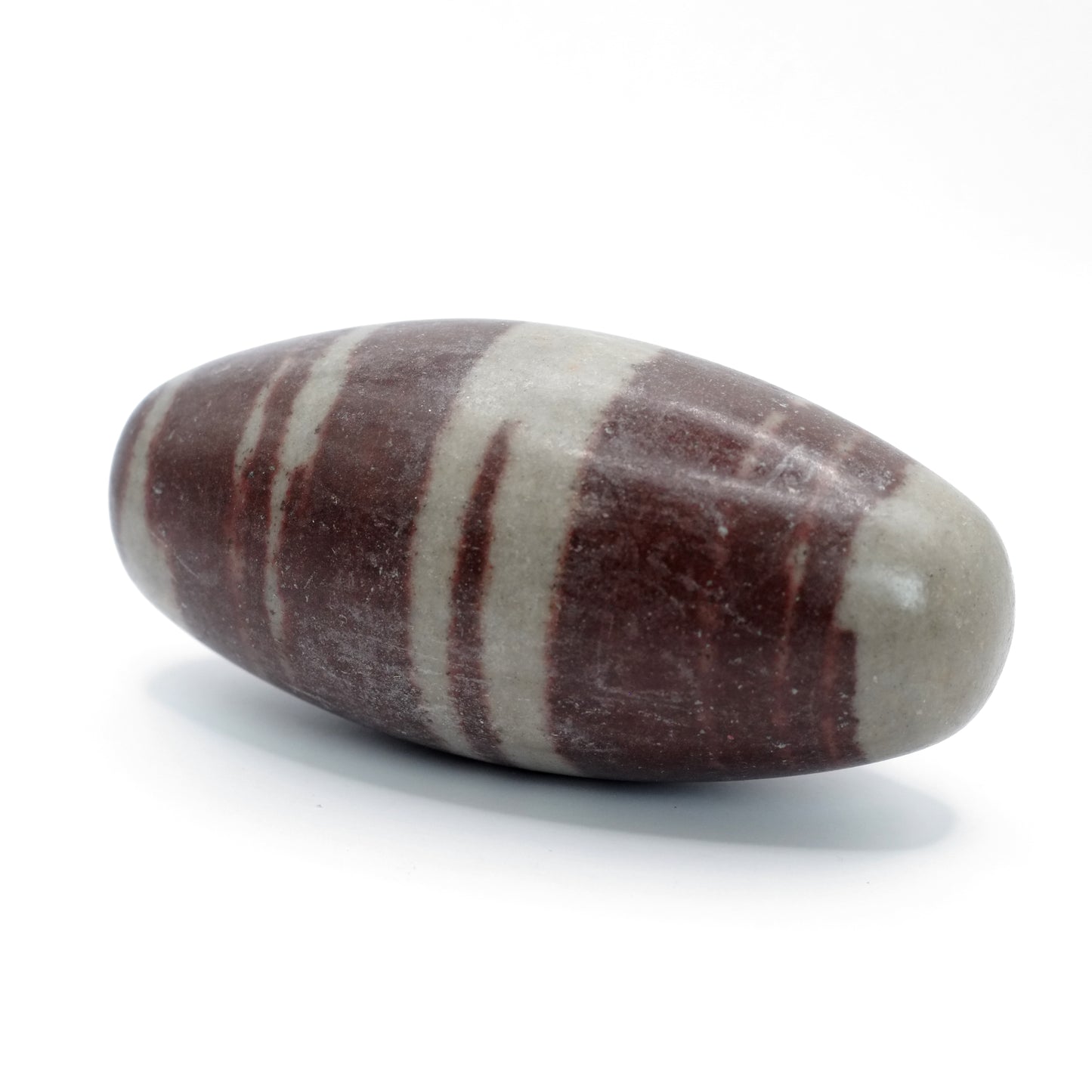 Pierre roulée en Shiva lingam de qualité A provenant d’Inde. Cette pierre de Shiva Lingam est bicolore, avec des rayures de couleurs beige et marron foncé.