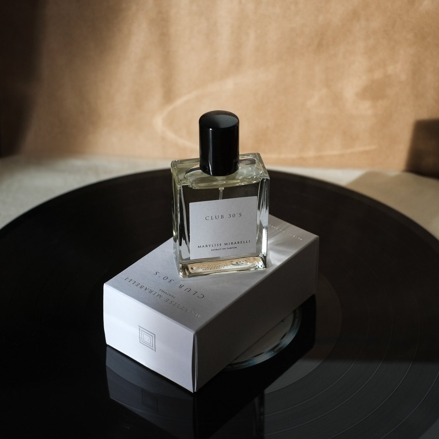 Le flacon de parfum Club 30's de Marylise Mirabelli posé sur sa boite blanche et disposé sur un album vinyle.