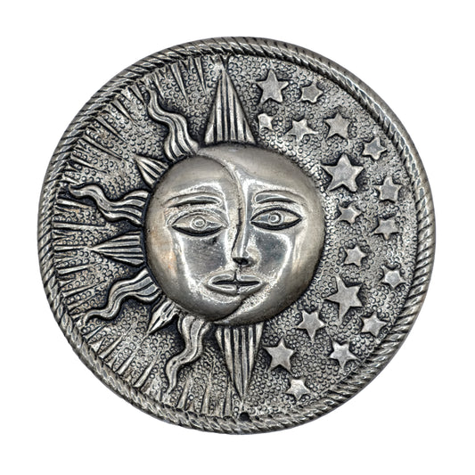 Ce porte-encens décoratif rond en aluminium recyclé, représente un soleil, une lune et des étoiles, symboliques d'une célébration céleste de la spiritualité.